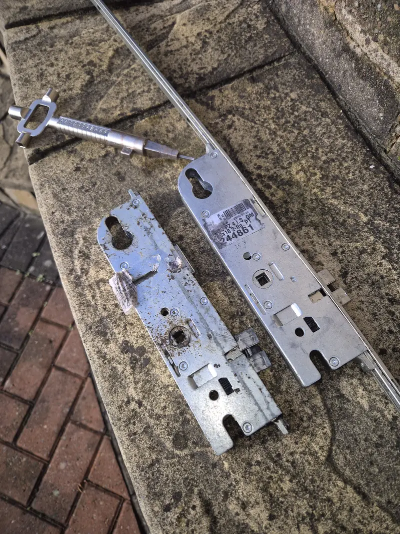 Replacement multipoint door lock mechanism beside the failed original unit in Leeds